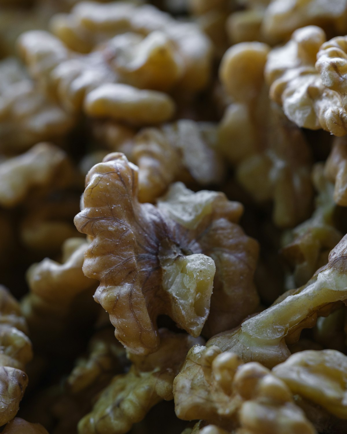 Shelled walnut halves in close-up, showing their ridged golden-brown texture